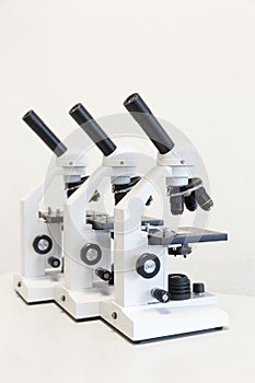 Three microscopes in a row isolated on background