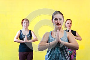 Three middle aged women practicing yoga in class