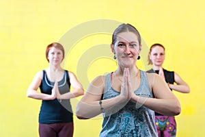 Three middle aged women practicing yoga in class