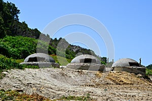 Three military bunkers from Enver Hoxha`s dictatorship near the beach at Cape of Rodon in Albania.