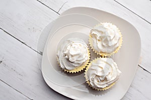 Three mini Cheesecakes with whipped cream icing on a white plate