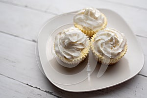 Three mini Cheesecakes with whipped cream icing on a white plate