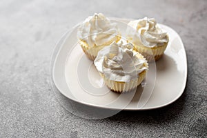 Three mini Cheesecakes with whipped cream icing on a white plate