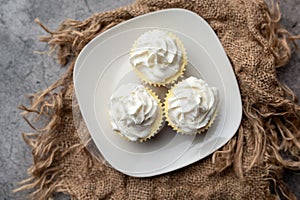 Three mini Cheesecakes with whipped cream icing on a white plate