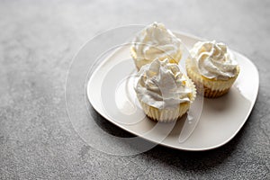 Three mini Cheesecakes with whipped cream icing on a white plate