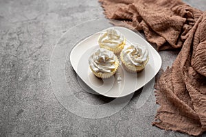 Three mini Cheesecakes with whipped cream icing on a white plate