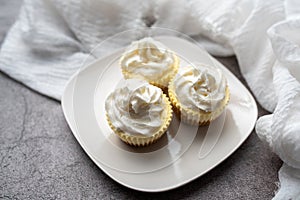 Three mini Cheesecakes with whipped cream icing on a white plate