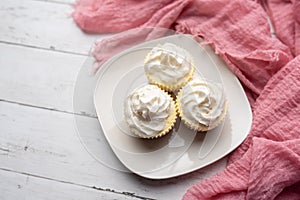 Three mini Cheesecakes with whipped cream icing on a white plate