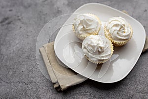 Three mini Cheesecakes with whipped cream icing on a white plate