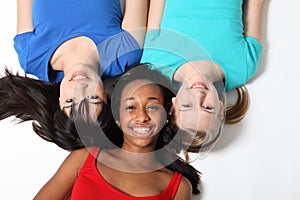 Three mixed race teenage girl friends on floor