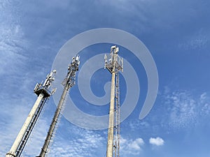 Three mobile phone telecommunication radio antenna towers. Cell phone tower, telecommunication tower mast TV antennas, blue sky,