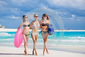 Three models on a tropical beach with a circle