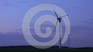 Three modern wind turbines generating sustainable energy in a field at evening on suburb of Hannover in Lower Saxony