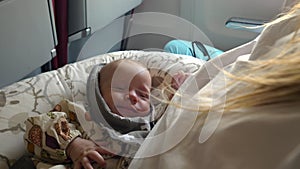 Three month baby girl smiling and looking at mother during the flight