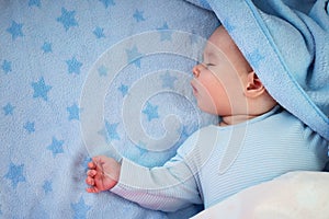 Three month old baby sleeping on blue blanket