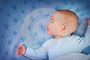 Three month old baby sleeping on blue blanket