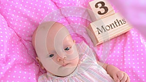 Three months baby girl in pink bassinet