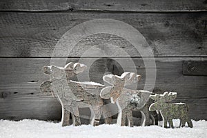 Three mooses or elks on a grey wooden background