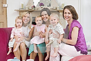 Three mothers in living room with babies