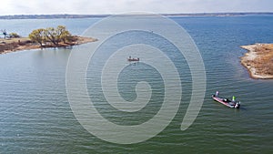 Three motor boats with fishermen spinning cast fishing at Murrell Park, Lake Grapevine, Texas