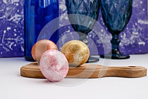 Three multi-colored easter eggs on a blue background