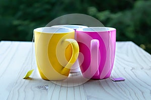 Three multi coloured mugs with tea