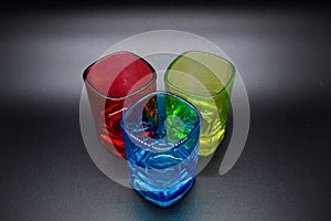 Three multicolored shot glasses on black background