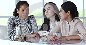 Three multiethnic girls laughing during teatime at home