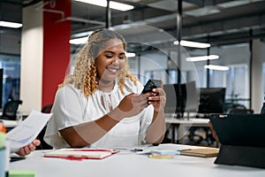 Three multiracial business people in businesswear using technology during meeting in office