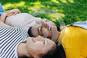 Three multiracial young women friends laughing together outdoors