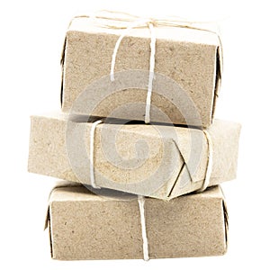 Three natural brown gift boxes or parcels with cord ribbon
