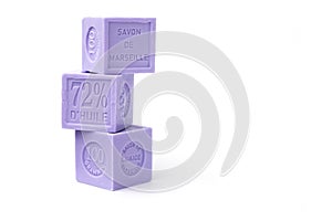 Three natural lavender soaps of a cubic form of lilac color with the inscription in French: Marseille lavender soap, 100