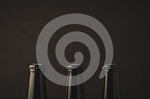 three necks with a stopper of beer bottles/ three necks with a stopper of beer bottles on a dark background. Copy space