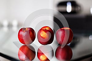 Three nectarines on the glass table