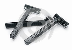 Three new black plastic disposable razors on white background