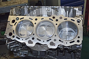 Three new pistons are installed in the engine cylinder block