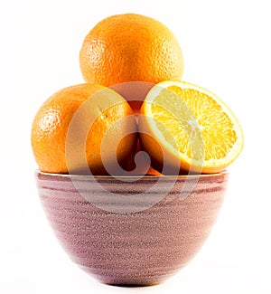 Three nicely colored oranges in a cup on a white background - front and back cut in half