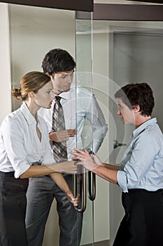 Three office workers at door of boardroom