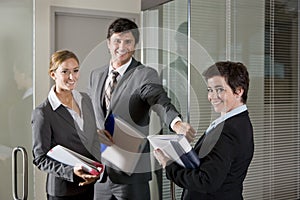 Three office workers at door of boardroom