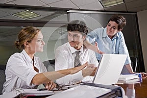 Three office workers meeting in boardroom