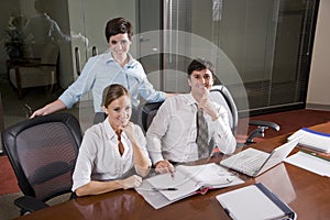 Three office workers working in boardroom