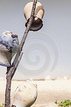 Three old broken jug on wooden stick upside down