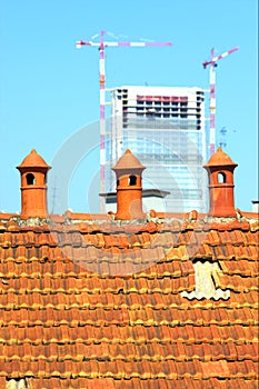 Three old chimney pot with modern construction in the background