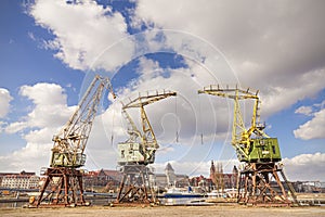 Three old cranes standing by the Odra River in Szczecin, city la