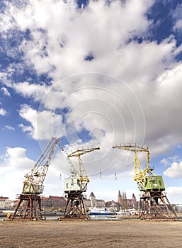 Three old cranes standing by the Odra River in Szczecin, city la