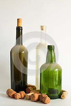 Three Old dust wine bottle and corks on white