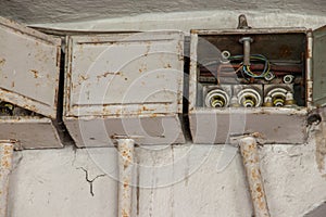 Three old electrical boxes on wall