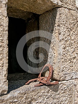 Three old horseshoes leaning against a window.