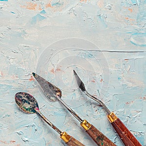 Three old palette knifes on artist canvas