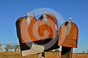 Three old rusty rural mailboxes